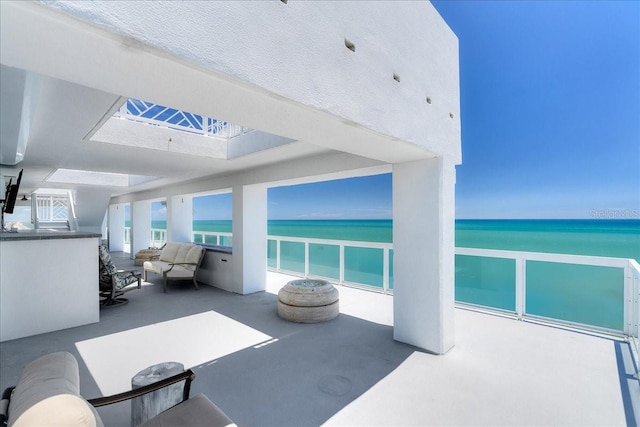 view of patio with a water view, a balcony, and an outdoor hangout area