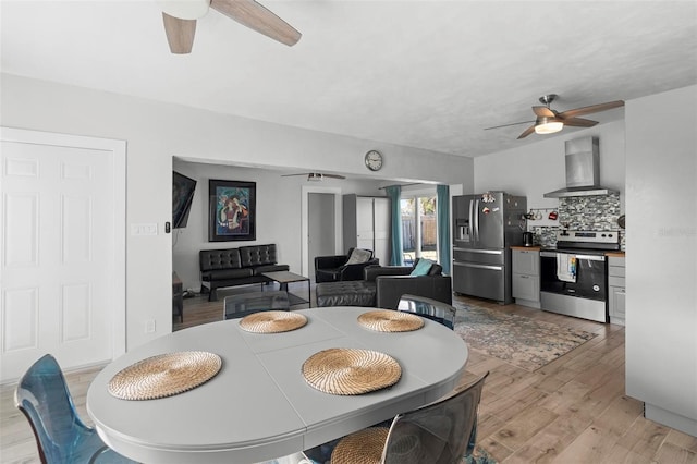 dining room with ceiling fan and light hardwood / wood-style flooring