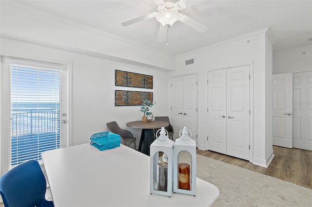 dining area featuring hardwood / wood-style flooring, ornamental molding, and ceiling fan