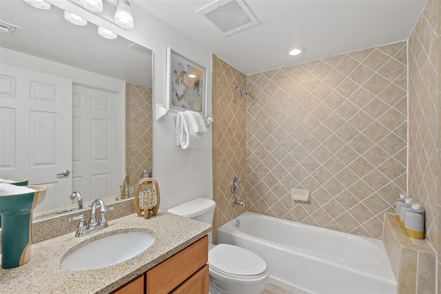 full bathroom featuring vanity, tiled shower / bath, and toilet