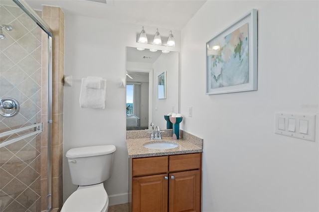 bathroom featuring vanity, an enclosed shower, and toilet