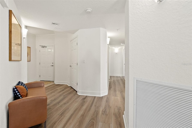 corridor with light hardwood / wood-style floors