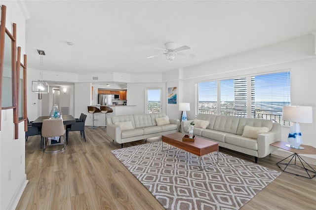 living room featuring ceiling fan and light hardwood / wood-style flooring