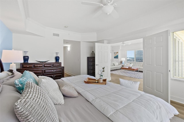 bedroom featuring crown molding, ceiling fan, and light wood-type flooring