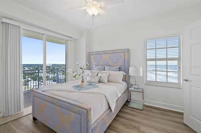 bedroom featuring wood-type flooring, multiple windows, and access to outside