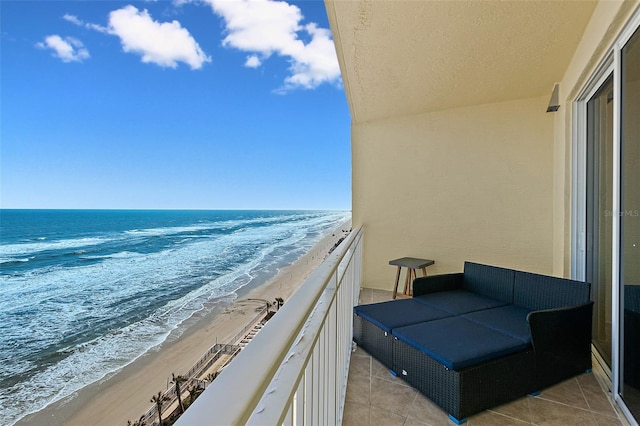 balcony featuring a water view and a beach view