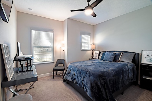 carpeted bedroom with multiple windows and ceiling fan