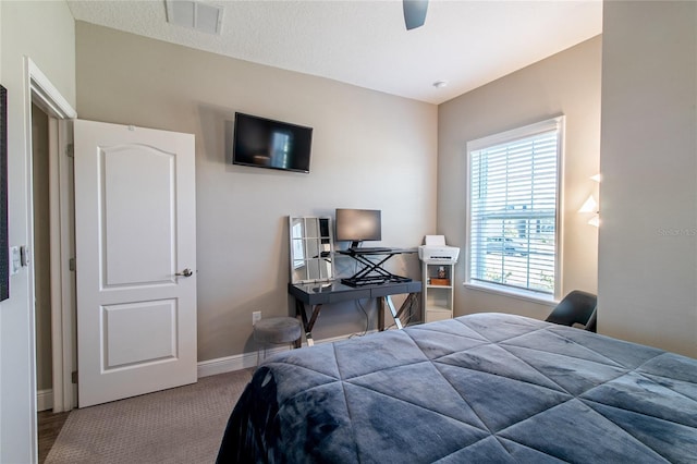 bedroom featuring ceiling fan, carpet flooring, and a textured ceiling