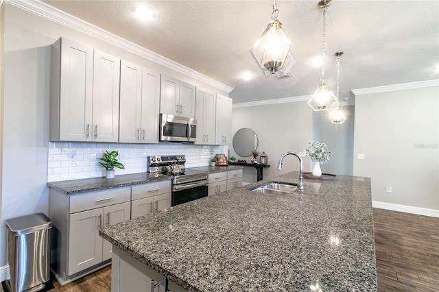 kitchen with pendant lighting, stainless steel appliances, dark wood-type flooring, and sink