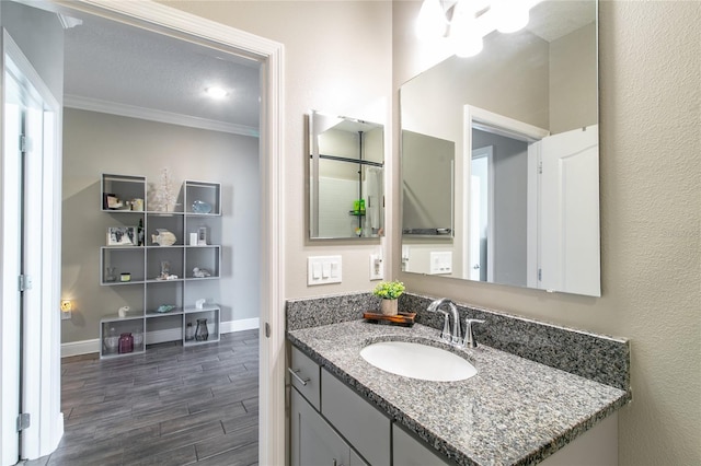 bathroom with wood-type flooring, crown molding, and vanity