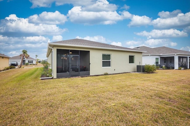 rear view of house with a lawn, cooling unit, and a sunroom