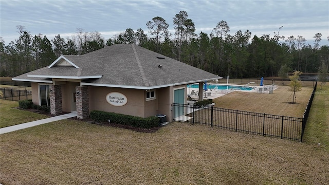 view of front facade with a community pool and a front yard