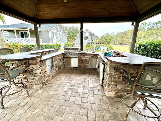 view of patio / terrace with stairs, a gazebo, outdoor wet bar, and a grill