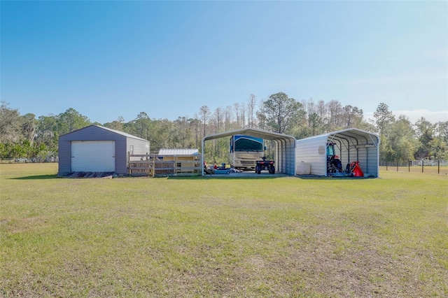 view of yard with an outbuilding, a carport, and fence