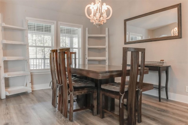 dining room featuring baseboards, an inviting chandelier, and wood finished floors