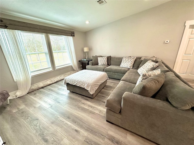 living room with recessed lighting, visible vents, baseboards, and wood finished floors