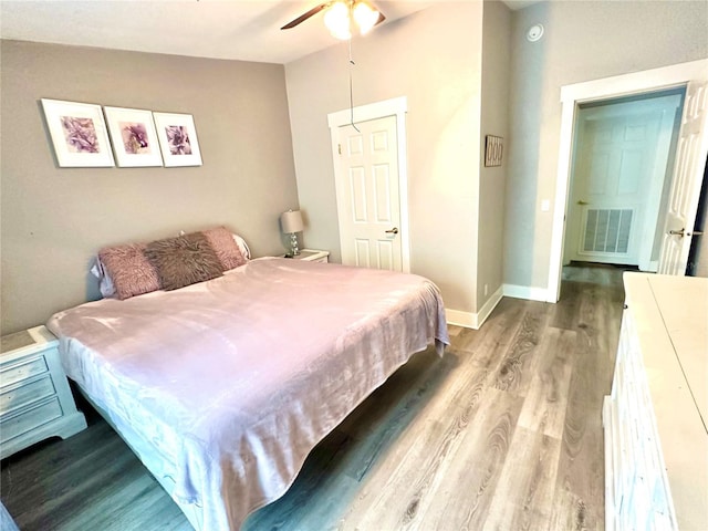 bedroom featuring visible vents, baseboards, wood finished floors, and a ceiling fan