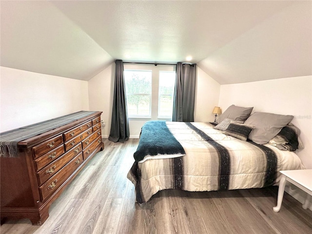 bedroom featuring wood finished floors and vaulted ceiling