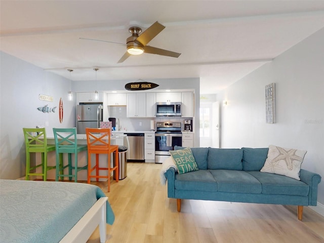 living room featuring ceiling fan and light wood-type flooring