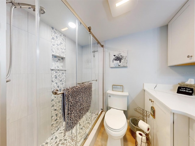 bathroom featuring a shower with door and toilet