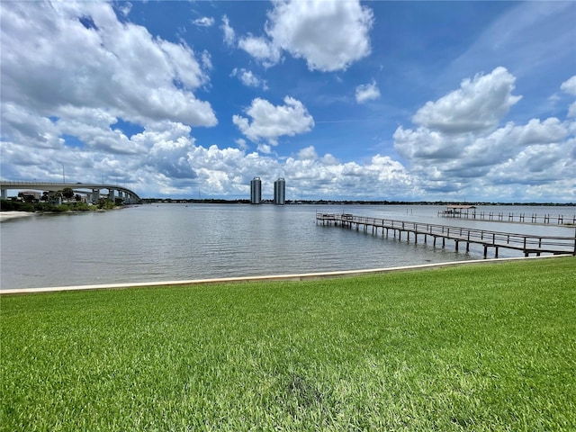 dock area with a water view and a lawn