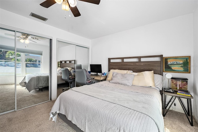 carpeted bedroom featuring two closets and ceiling fan