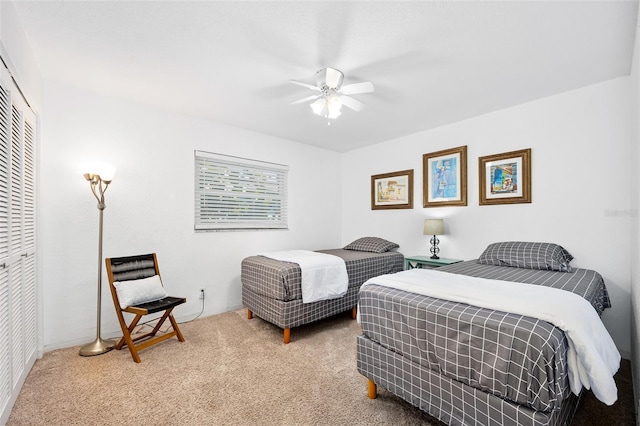 carpeted bedroom with ceiling fan and a closet