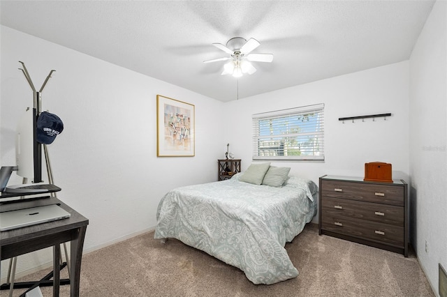 bedroom featuring ceiling fan, light colored carpet, and a textured ceiling