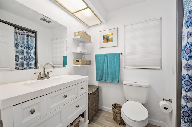 bathroom featuring vanity, toilet, and hardwood / wood-style floors