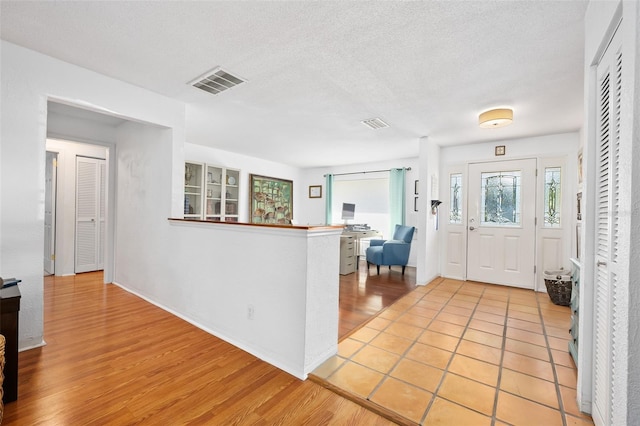 entryway featuring a textured ceiling and light hardwood / wood-style floors