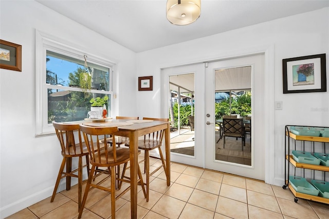 dining area featuring french doors and light tile patterned flooring