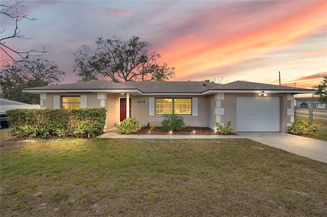 ranch-style home with a garage and a lawn