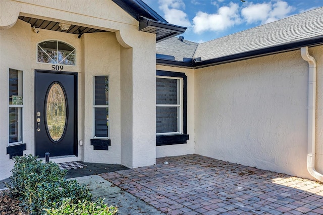 view of exterior entry with a patio