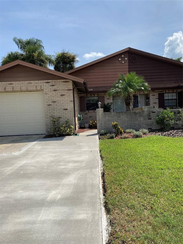 ranch-style home with a garage and a front lawn