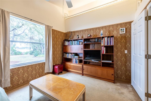 living room featuring carpet floors, wallpapered walls, and a ceiling fan