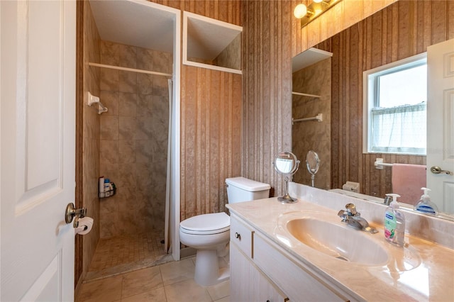 full bathroom featuring wallpapered walls, tiled shower, toilet, tile patterned flooring, and vanity