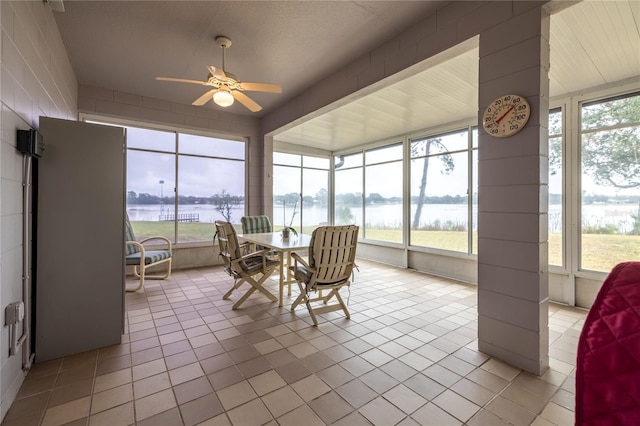 sunroom featuring a water view, plenty of natural light, and a ceiling fan
