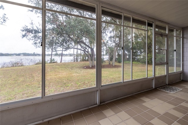 unfurnished sunroom featuring a water view
