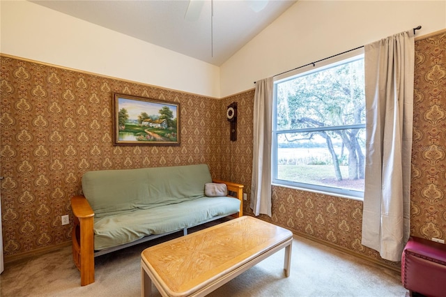 living area featuring lofted ceiling, carpet floors, ceiling fan, and wallpapered walls