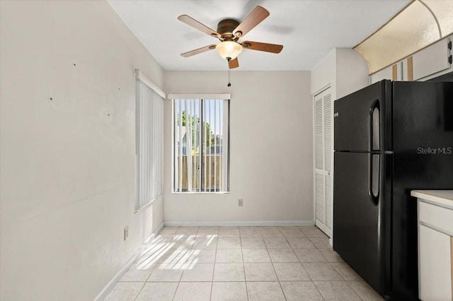 kitchen with freestanding refrigerator, light tile patterned flooring, light countertops, baseboards, and ceiling fan