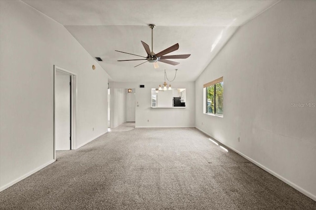 unfurnished living room with vaulted ceiling, ceiling fan with notable chandelier, baseboards, and light carpet