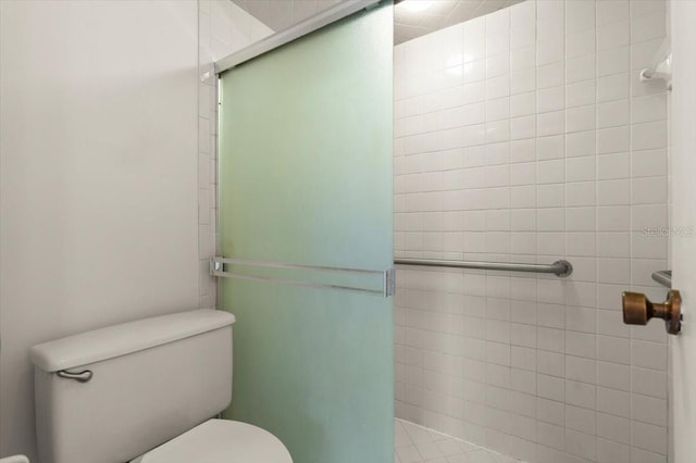 bathroom with toilet and tiled shower