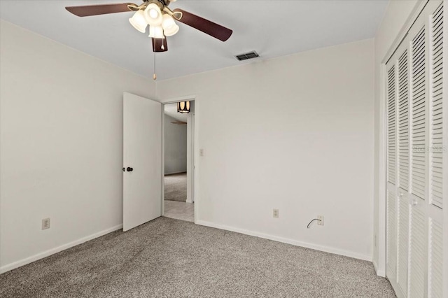 unfurnished bedroom featuring carpet, visible vents, baseboards, ceiling fan, and a closet