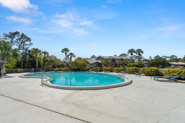 community pool featuring a patio and fence