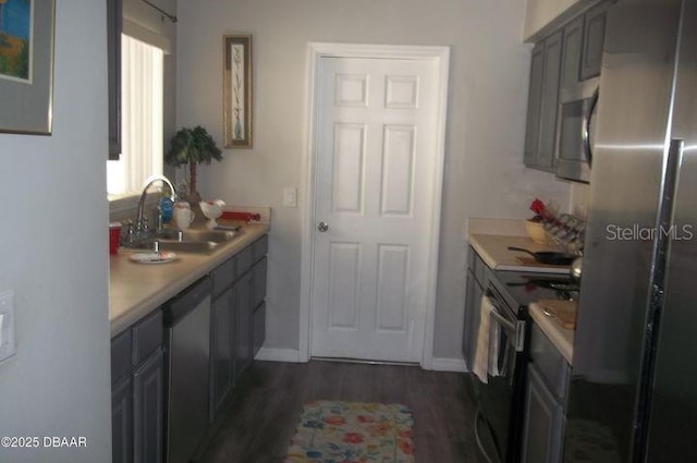 kitchen featuring stainless steel appliances, sink, dark hardwood / wood-style floors, and gray cabinets