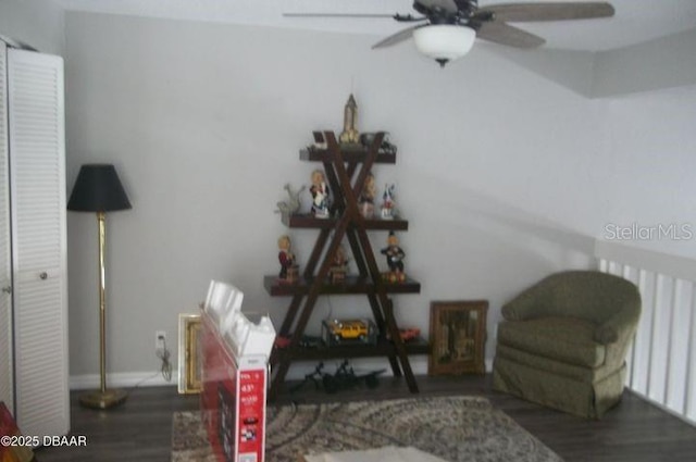 living area featuring dark hardwood / wood-style flooring and ceiling fan