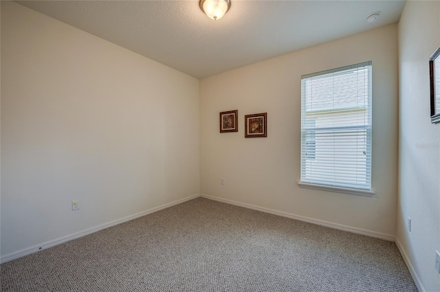 carpeted empty room with a textured ceiling