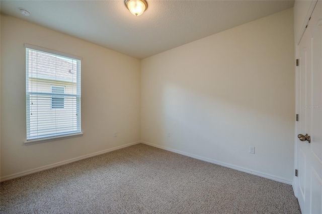 carpeted empty room featuring a textured ceiling