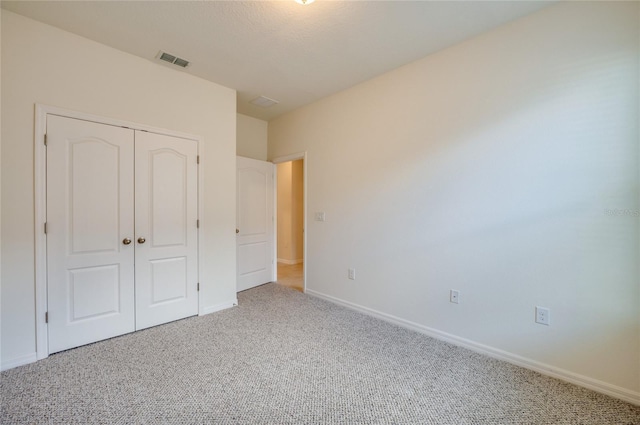 unfurnished bedroom featuring carpet and a closet