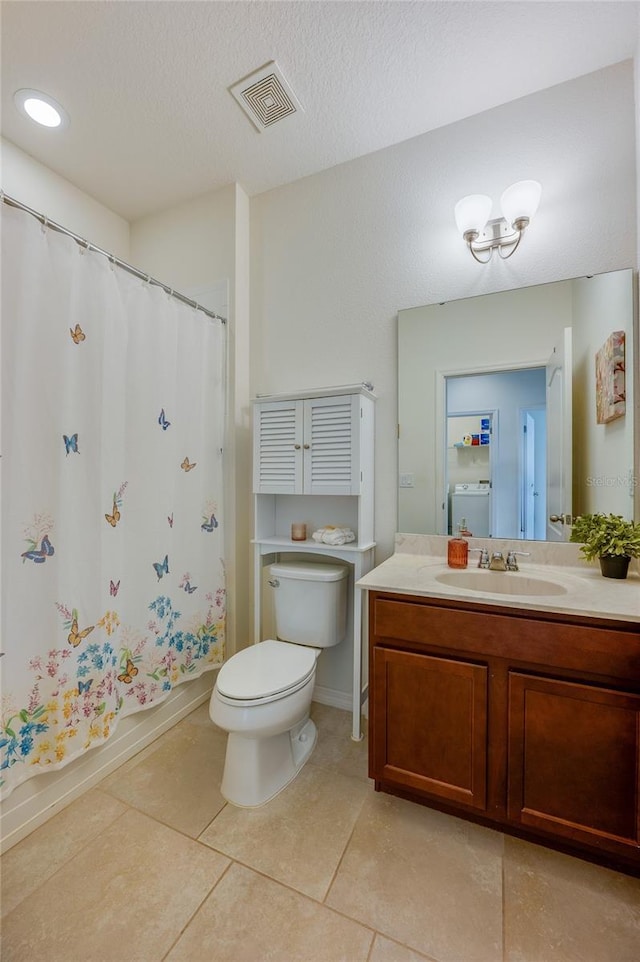 bathroom featuring toilet, washer / dryer, a textured ceiling, vanity, and tile patterned flooring